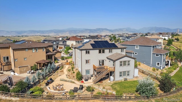 back of house with a mountain view and solar panels