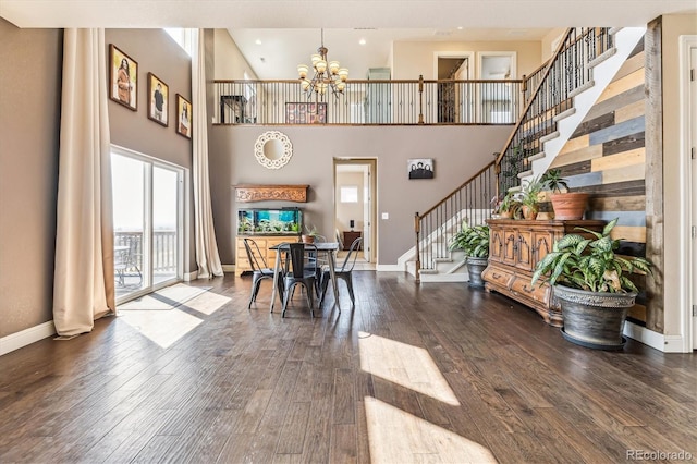 dining room with a notable chandelier, hardwood / wood-style flooring, and a towering ceiling