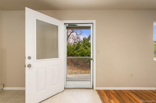 entryway with baseboards and light tile patterned floors