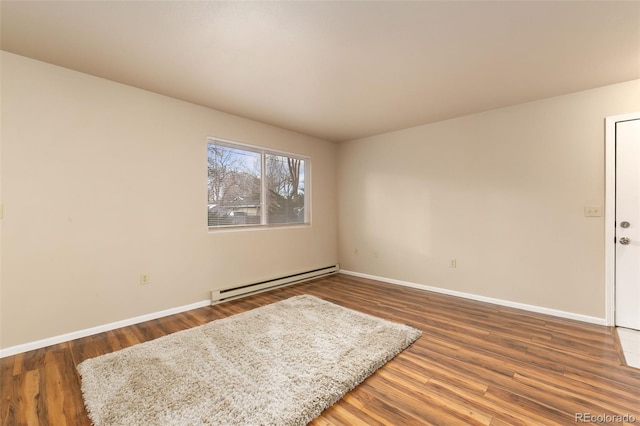 unfurnished room featuring a baseboard radiator, baseboards, and wood finished floors