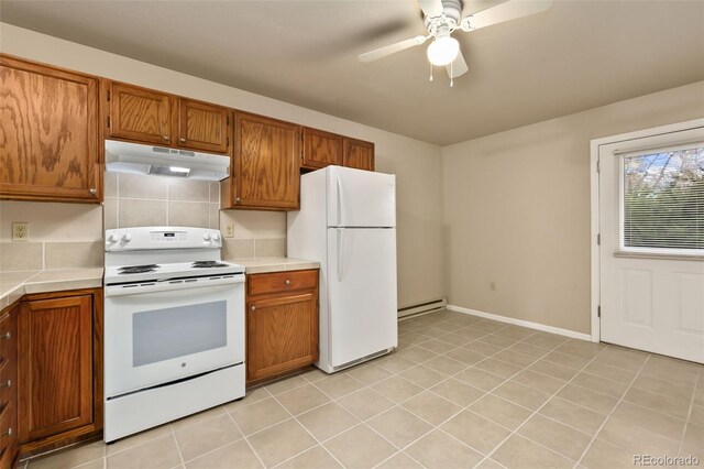 1502 E 5th St, Loveland, CO 80537 - kitchen with baseboard heating, white appliances, brown cabinets, tile counters, and under cabinet range hood