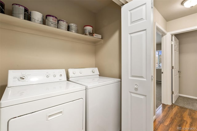 clothes washing area with washing machine and clothes dryer, wood finished floors, laundry area, and baseboards