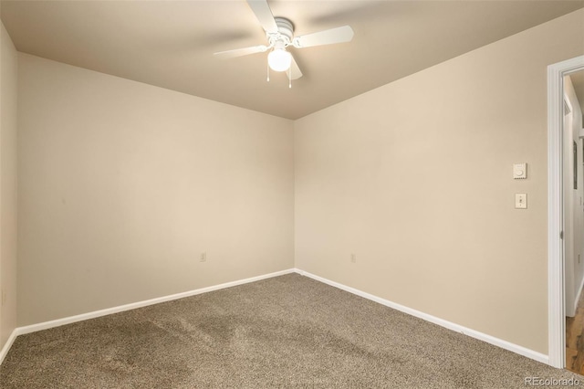 empty room with baseboards, dark carpet, and ceiling fan