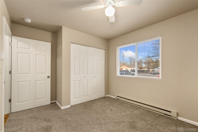 unfurnished bedroom featuring baseboards, carpet, baseboard heating, a closet, and ceiling fan