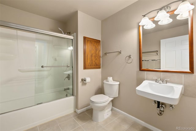full bathroom featuring a sink, baseboards, enclosed tub / shower combo, toilet, and tile patterned flooring