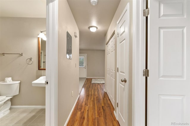 corridor featuring wood finished floors and baseboards