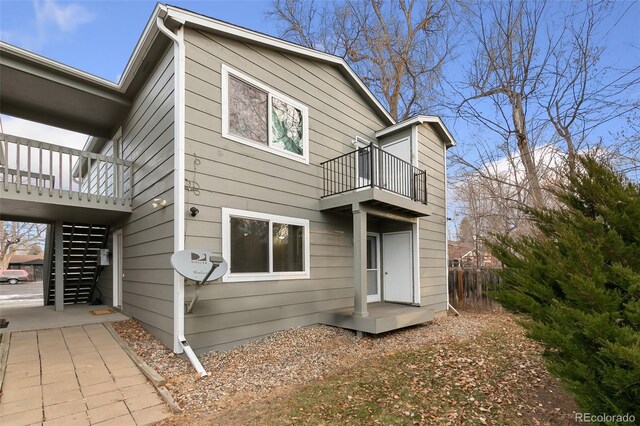 1502 E 5th St, Loveland, CO 80537 - rear view of property with fence, a balcony, and stairs
