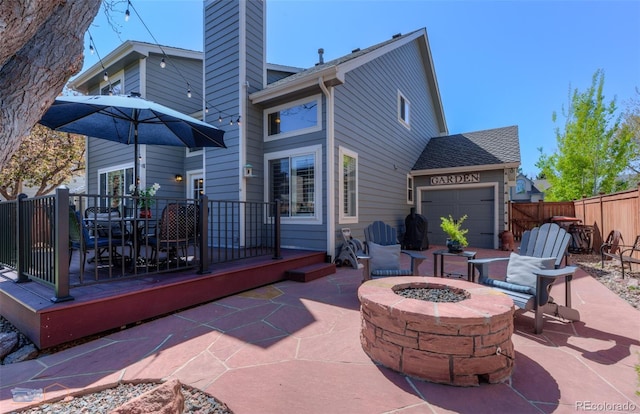 14533 W 69th Pl, Arvada, CO 80004 - view of patio with a fire pit, a garage, and outdoor dining area