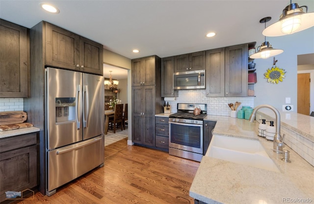 14533 W 69th Pl, Arvada, CO 80004 - kitchen with stainless steel appliances, tasteful backsplash, a chandelier, a sink, and open shelves