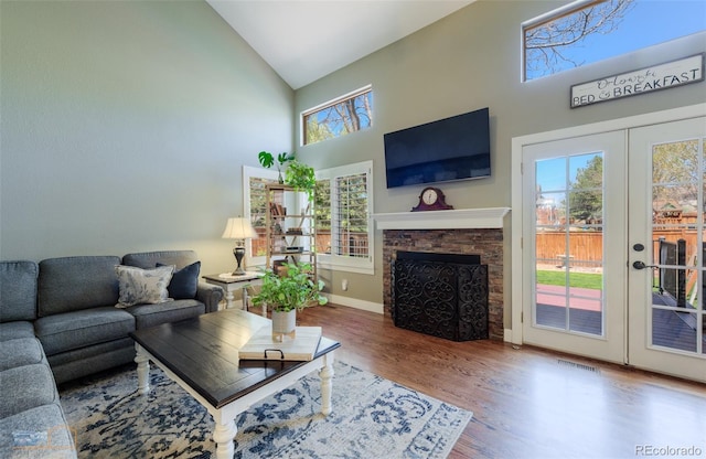 14533 W 69th Pl, Arvada, CO 80004 - living room with high vaulted ceiling, wood finished floors, french doors, baseboards, and a fireplace