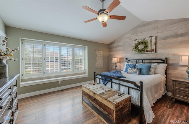 14533 W 69th Pl, Arvada, CO 80004 - bedroom with vaulted ceiling, wood walls, wood finished floors, baseboards, and a ceiling fan