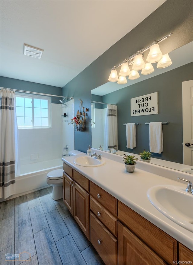 14533 W 69th Pl, Arvada, CO 80004 - full bathroom with double vanity, shower / tub combo, toilet, and wood finish floors