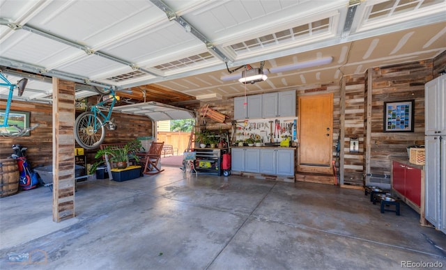 14533 W 69th Pl, Arvada, CO 80004 - garage with wood walls, a garage door opener, and a workshop area