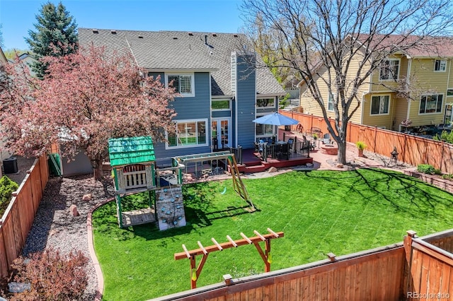 14533 W 69th Pl, Arvada, CO 80004 - back of house with a wooden deck, roof with shingles, and a playground