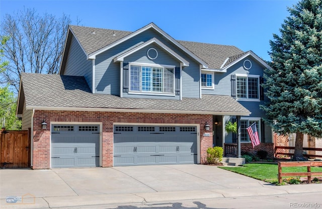 14533 W 69th Pl, Arvada, CO 80004 - view of front of house with brick siding, driveway, roof with shingles, and a garage