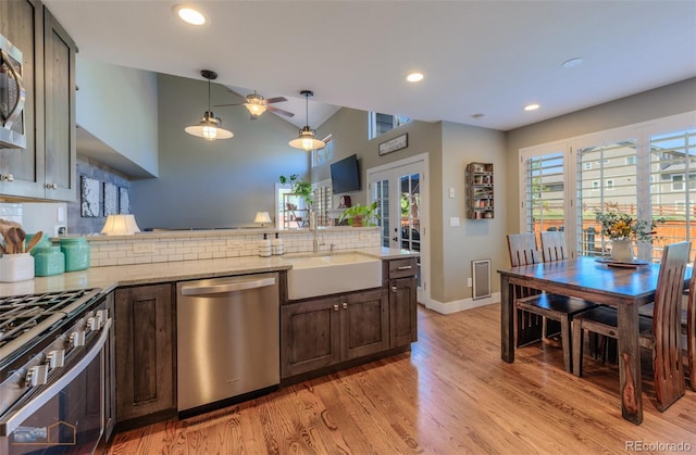 14533 W 69th Pl, Arvada, CO 80004 - kitchen with appliances with stainless steel finishes, a sink, light wood finished floors, decorative backsplash, and a peninsula