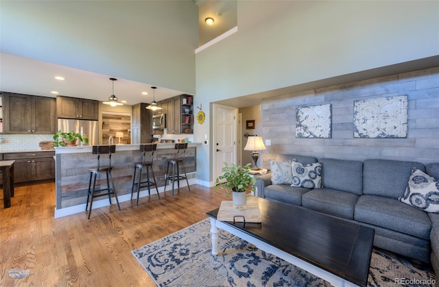 14533 W 69th Pl, Arvada, CO 80004 - living area with light wood-type flooring, baseboards, and a high ceiling