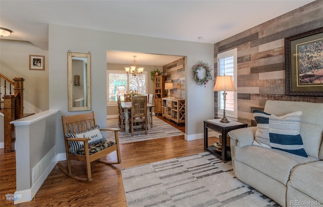 14533 W 69th Pl, Arvada, CO 80004 - living room featuring a chandelier, wood finished floors, an accent wall, plenty of natural light, and wooden walls