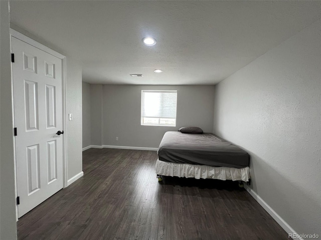 bedroom with dark hardwood / wood-style floors