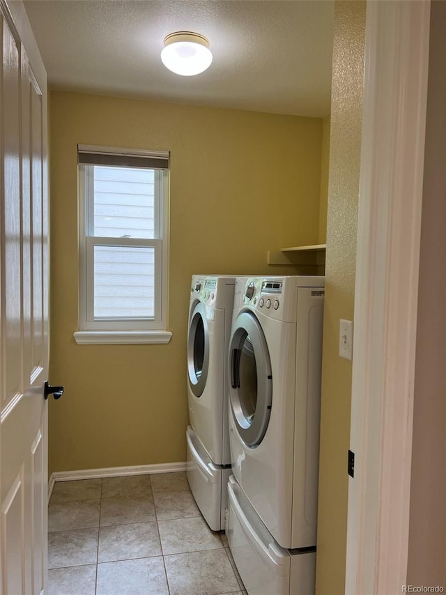 laundry room featuring light tile patterned flooring, washer and dryer, and a textured ceiling