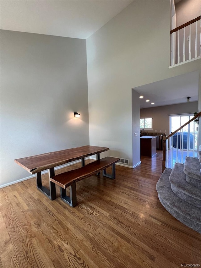 dining area featuring dark hardwood / wood-style floors and high vaulted ceiling