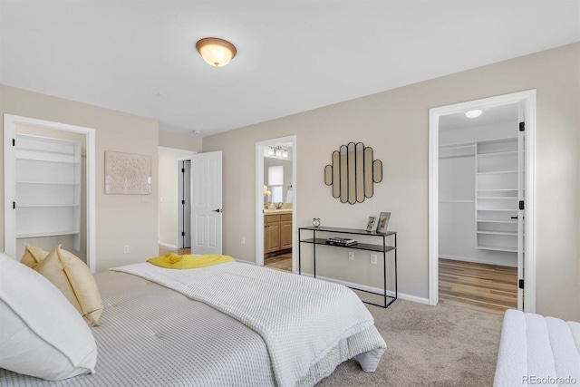 bedroom featuring a walk in closet, light colored carpet, and a closet