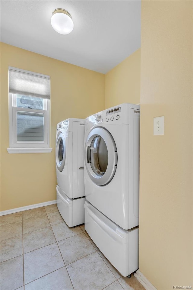 laundry area with light tile patterned floors and washer and dryer