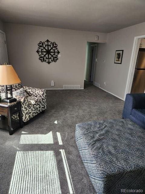 carpeted living area featuring visible vents and baseboards