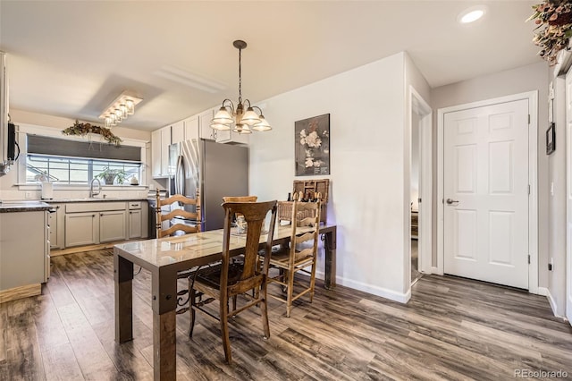 dining area with baseboards, dark wood finished floors, a notable chandelier, and recessed lighting