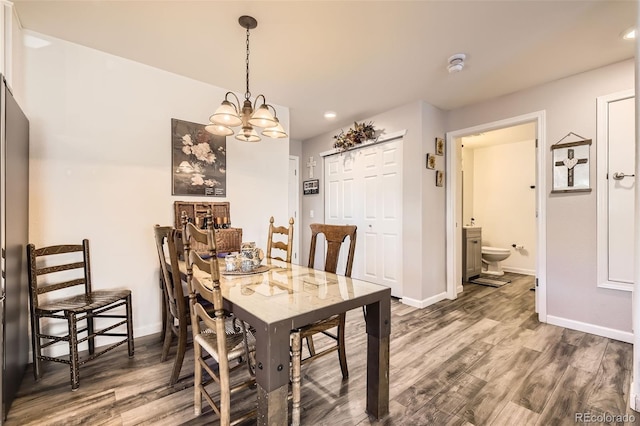 dining room with recessed lighting, baseboards, an inviting chandelier, and wood finished floors