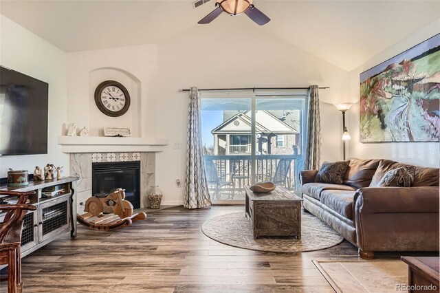 living room featuring visible vents, a tiled fireplace, a ceiling fan, wood finished floors, and vaulted ceiling