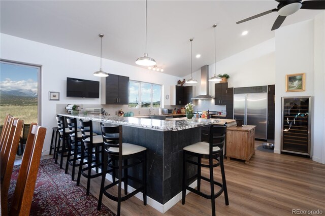 11865 Rangeview Cir, Salida, CO 81201 - kitchen with wall chimney exhaust hood, wine cooler, stainless steel built in fridge, a sink, and a kitchen breakfast bar