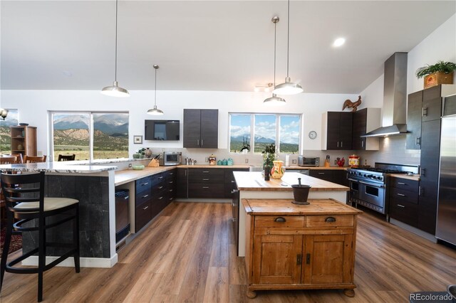 11865 Rangeview Cir, Salida, CO 81201 - kitchen with wall chimney exhaust hood, premium stove, plenty of natural light, and a peninsula