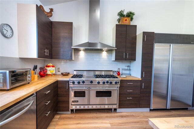 11865 Rangeview Cir, Salida, CO 81201 - kitchen featuring high end appliances, wall chimney exhaust hood, wood counters, and dark brown cabinets