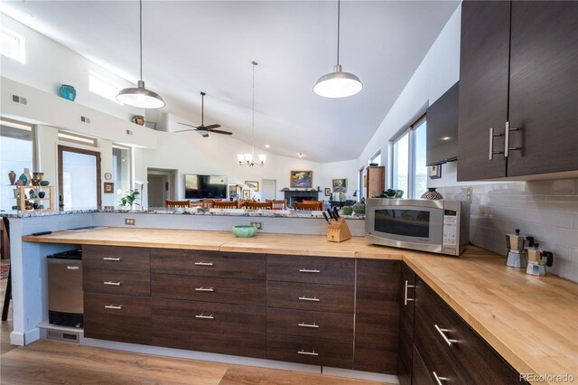 11865 Rangeview Cir, Salida, CO 81201 - kitchen featuring wood counters, stainless steel microwave, lofted ceiling, decorative backsplash, and open floor plan