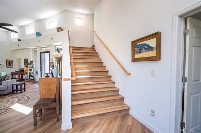 11865 Rangeview Cir, Salida, CO 81201 - stairs featuring wood finished floors, a ceiling fan, and a towering ceiling