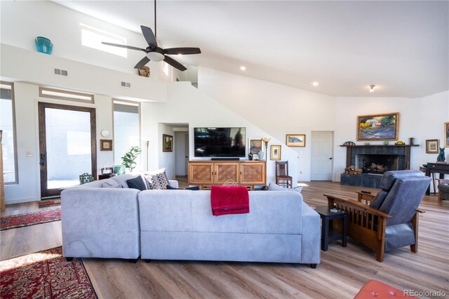 11865 Rangeview Cir, Salida, CO 81201 - living room featuring wood finished floors, ceiling fan, a tiled fireplace, recessed lighting, and high vaulted ceiling