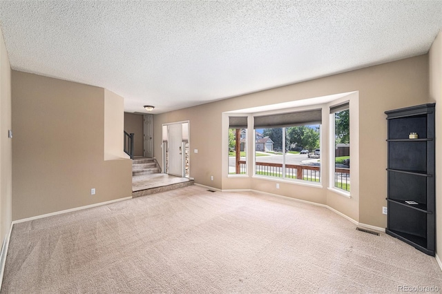 5573 S Taft St, Littleton, CO 80127 - unfurnished living room featuring light carpet, stairway, baseboards, and a textured ceiling