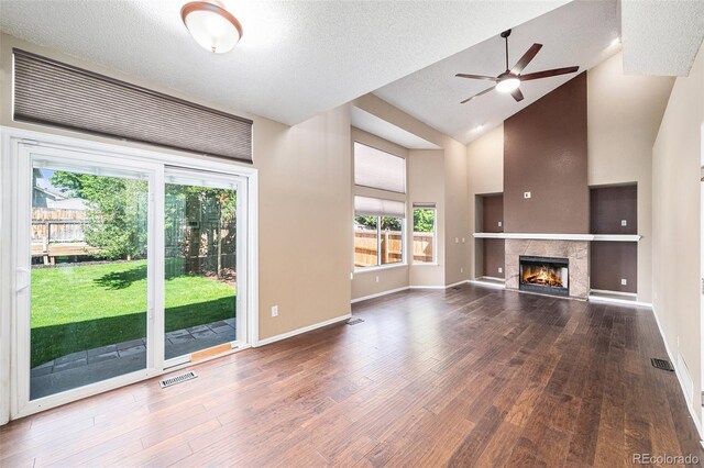 5573 S Taft St, Littleton, CO 80127 - unfurnished living room with a ceiling fan, wood finished floors, high vaulted ceiling, a textured ceiling, and a tile fireplace