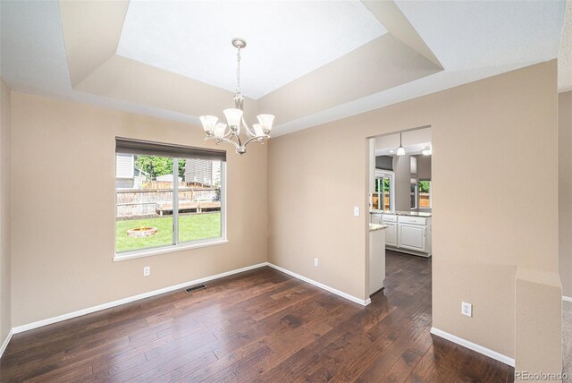 5573 S Taft St, Littleton, CO 80127 - unfurnished room featuring a raised ceiling, a chandelier, dark wood-style flooring, and baseboards