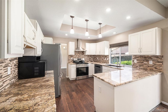 5573 S Taft St, Littleton, CO 80127 - kitchen with stainless steel appliances, wall chimney range hood, a sink, a raised ceiling, and light stone counters
