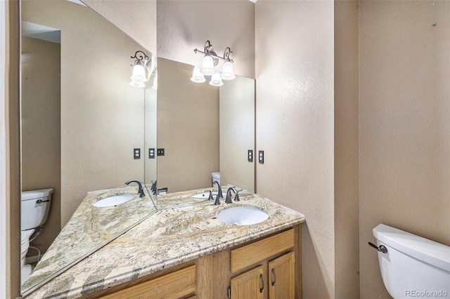 5573 S Taft St, Littleton, CO 80127 - bathroom featuring toilet, double vanity, and a textured wall