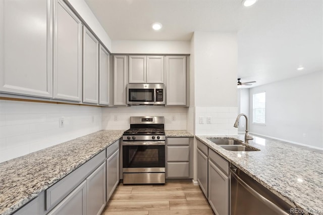 3831 E 141st Ave, Thornton, CO 80602 - kitchen featuring stainless steel appliances, a sink, gray cabinetry, light stone counters, and recessed lighting