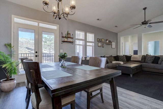 dining space with vaulted ceiling, a wealth of natural light, light hardwood / wood-style floors, and french doors