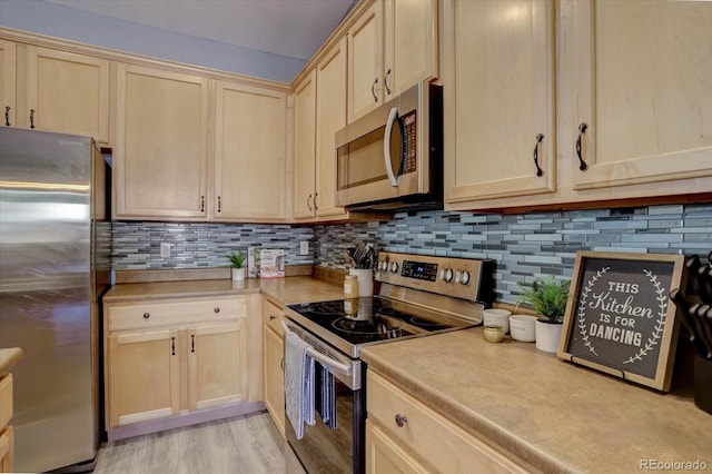 kitchen with tasteful backsplash, appliances with stainless steel finishes, light brown cabinetry, and light hardwood / wood-style floors