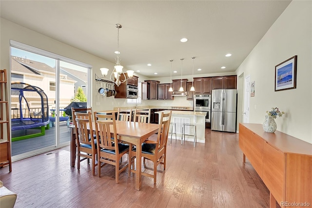 dining room featuring hardwood / wood-style floors and an inviting chandelier