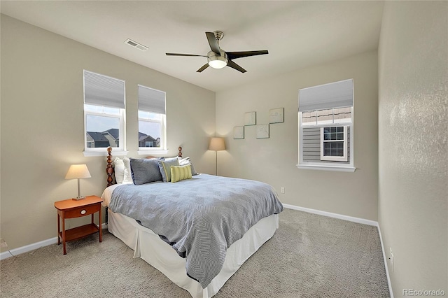 carpeted bedroom featuring multiple windows and ceiling fan