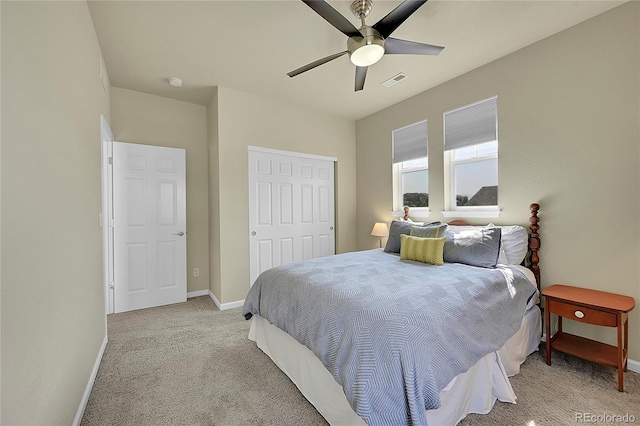 bedroom featuring light colored carpet, a closet, and ceiling fan