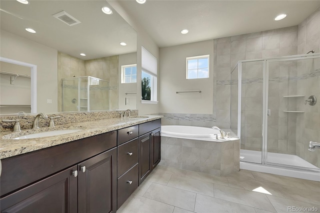 bathroom featuring dual vanity, shower with separate bathtub, and tile patterned flooring