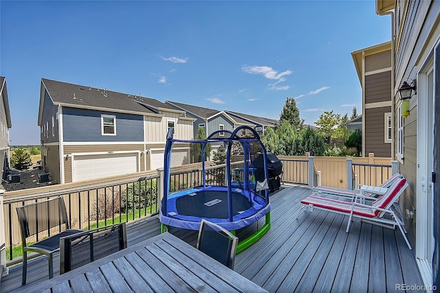 deck featuring a garage and a trampoline